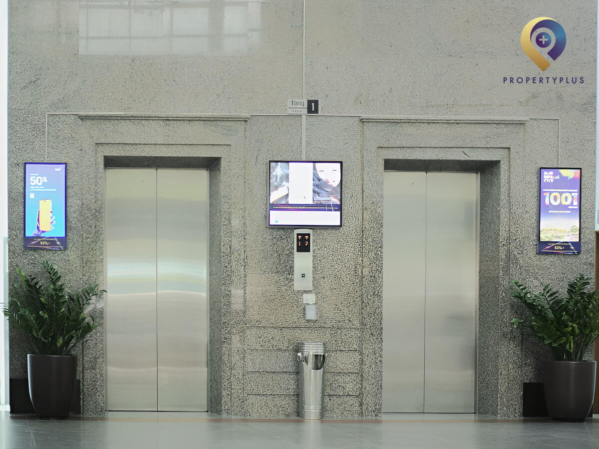 Modern elevators inside 14 Lang Ha building with digital displays and stainless steel doors.